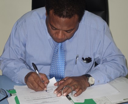 MEHRD Minister Dr Derek Sikua signing the release of the Form Six placement results. Photo credit: SIBC.
