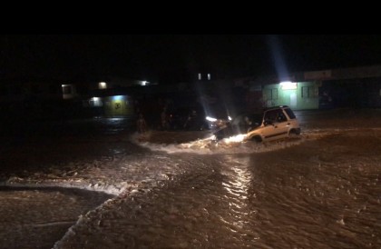 A car plows through the flood water on Kukum Highway last night. It made it. 
