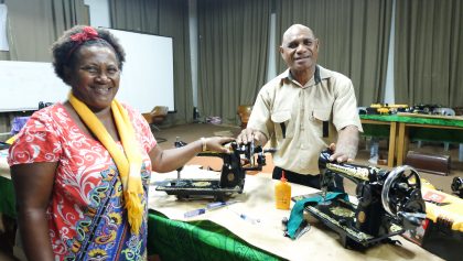Couple stitching up sewing machine repair workshops